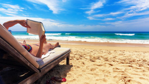 woman in bikini reading a book at the beach