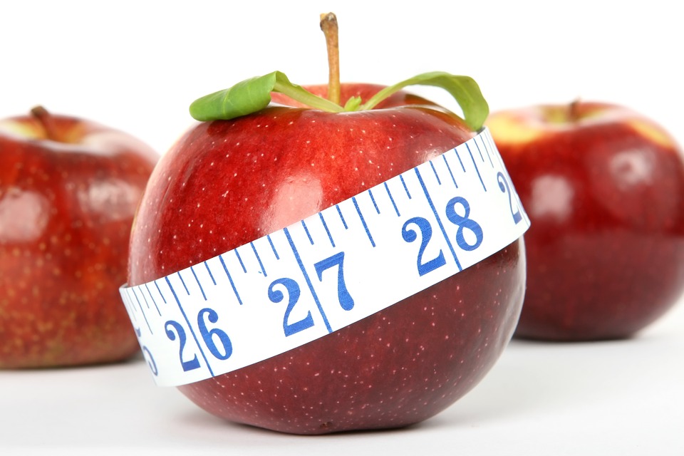 3 red apples, the center wrapped with a tape measure